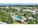 Aerial view of a community pool surrounded by lush landscaping and palm trees, resort-style amenities at 7509 Mourning Dove Cir # 201, Reunion, FL 34747