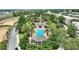 Aerial view of a community pool area featuring gazebos, palm trees, and well-maintained landscaping at 7509 Mourning Dove Cir # 201, Reunion, FL 34747