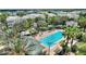 Aerial view of a community pool featuring a hot tub, sun loungers, and swaying palm trees at 7509 Mourning Dove Cir # 201, Reunion, FL 34747