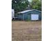 Exterior view of outbuilding with a large garage door perfect for workshop or storage at 8704 Tom Costine Rd, Lakeland, FL 33809