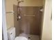 This bathroom offers a walk-in shower with tan tile and safety bars, and a modern toilet at 8750 Se 88Th Ave, Ocala, FL 34472