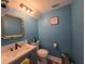 Stylish half bath with blue walls, modern vanity, and elegant fixtures at 101 Grand Junction Blvd, Orlando, FL 32835
