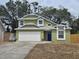 Charming two-story home with a white garage door and a blue front door framed by bright green walls at 101 Grand Junction Blvd, Orlando, FL 32835