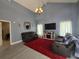 Spacious living room with high ceilings, gray walls, wood floors, and comfortable seating around a TV at 101 Grand Junction Blvd, Orlando, FL 32835