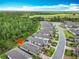 Property aerial showcasing home in relation to the community, nearby woods, and road; red arrow indicates location at 1029 Umbria Dr, Poinciana, FL 34759