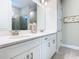 Bright bathroom with double sinks, white cabinetry, and glass-enclosed shower at 1029 Umbria Dr, Poinciana, FL 34759