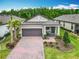 Beautiful single-story home with a well-manicured lawn and a welcoming covered entrance and a brick-paved driveway at 1029 Umbria Dr, Poinciana, FL 34759