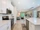 Modern kitchen featuring white shaker cabinets, stainless steel appliances, and a large island with seating at 1029 Umbria Dr, Poinciana, FL 34759