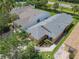 A high angle view of the home, manicured landscaping, and a brick paved driveway and walkway at 112 Grand Canal Dr, Poinciana, FL 34759