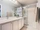Bathroom featuring a white vanity with storage, a mirror, and a glass enclosed shower at 112 Grand Canal Dr, Poinciana, FL 34759