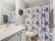 Bathroom with flowered shower curtain, marble countertops and decorative wreath at 112 Grand Canal Dr, Poinciana, FL 34759