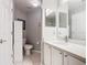 Bathroom with white vanity, modern fixtures, a toilet, and a linen closet for extra storage space at 112 Grand Canal Dr, Poinciana, FL 34759