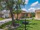 Charming front yard with lush lawn, landscaping, and a brick paved driveway leading to the home at 112 Grand Canal Dr, Poinciana, FL 34759