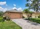 A well-maintained home featuring a two-car garage and a neatly paved brick driveway and walkway at 112 Grand Canal Dr, Poinciana, FL 34759
