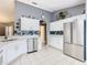 Well-lit kitchen with stainless steel appliances, white cabinets, tile floors, backsplash and decor at 112 Grand Canal Dr, Poinciana, FL 34759