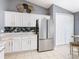 Updated kitchen with stainless steel refrigerator, white cabinets, tile floors and backsplash at 112 Grand Canal Dr, Poinciana, FL 34759