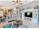 Open living room features neutral walls, tile floors, comfortable seating, and custom built-ins at 112 Grand Canal Dr, Poinciana, FL 34759