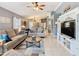 Comfortable living room with tile flooring, modern ceiling fan, and an entertainment center with a television at 112 Grand Canal Dr, Poinciana, FL 34759