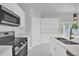 Modern kitchen featuring white cabinets, stainless steel appliances, and a stylish black sink faucet at 1251 Ash Tree Cv, Casselberry, FL 32707
