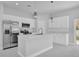 Bright kitchen boasts stainless steel appliances, white quartz countertops, and elegant pendant lighting at 1251 Ash Tree Cv, Casselberry, FL 32707