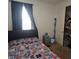 Comfortable bedroom featuring a patterned bedspread, a window with curtains, and an organized closet at 19235 Allium Pl, Orlando, FL 32827