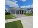Charming single-story home with a well-manicured lawn, gray garage doors, and a beautiful stone facade at 19235 Allium Pl, Orlando, FL 32827