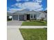 Charming single-story home with a well-manicured lawn, gray garage doors, and a beautiful stone facade at 19235 Allium Pl, Orlando, FL 32827