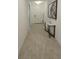 Inviting hallway featuring a white door, light tile flooring, a stylish table, and decorative wall art at 19235 Allium Pl, Orlando, FL 32827