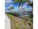 Community pool area with palm trees, lounge chairs, and a black metal fence at 19235 Allium Pl, Orlando, FL 32827