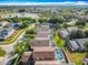 An aerial view shows a neighborhood with lush trees and screened in pools near a lake with a fountain at 207 Bailey Cir, Davenport, FL 33897