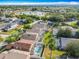 An aerial view shows a neighborhood with screened in pools and a lake with a fountain at 207 Bailey Cir, Davenport, FL 33897