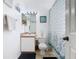 Light-filled bathroom features a patterned shower curtain, vanity, and ceramic tile floors at 207 Bailey Cir, Davenport, FL 33897