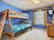 Bright bedroom with a bunk bed, window, and wooden dresser at 207 Bailey Cir, Davenport, FL 33897