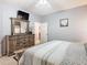 Cozy bedroom with wood dresser, mounted television, and relaxing neutral color palette at 207 Bailey Cir, Davenport, FL 33897