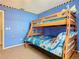 Fun bedroom with a wooden bunk bed, blue walls, and colorful Minion-themed decorations at 207 Bailey Cir, Davenport, FL 33897