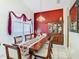 Formal dining room with a long table, decorative china cabinet, chandelier, and large window dressed with valances at 207 Bailey Cir, Davenport, FL 33897