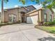 Charming stucco home featuring a two-car garage, well-manicured landscaping, and a welcoming front entrance at 207 Bailey Cir, Davenport, FL 33897
