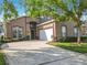 Attractive stucco home with a two-car garage, tidy landscaping, and an inviting front door at 207 Bailey Cir, Davenport, FL 33897