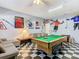 Spacious game room with a pool table, comfortable seating, and sports-themed decor for entertainment at 207 Bailey Cir, Davenport, FL 33897