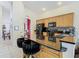 Open kitchen features black granite countertops, seating for two, and light wood cabinets at 207 Bailey Cir, Davenport, FL 33897