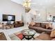 Spacious living room featuring vaulted ceilings, tile flooring, two sofas, and a large flatscreen television at 207 Bailey Cir, Davenport, FL 33897