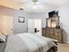 Calm bedroom features a wooden dresser, an ensuite bathroom, and plush carpeting at 207 Bailey Cir, Davenport, FL 33897