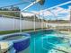 Beautiful screened pool and spa with clear blue water, perfect for swimming and relaxation at 207 Bailey Cir, Davenport, FL 33897