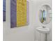 Stylish half-bathroom features a modern pedestal sink and artistic wall decor at 2302 Tay Wes Dr, St Cloud, FL 34771
