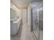 Bathroom with double vanity, tiled floors, and a glass-enclosed shower at 2310 Raven Ridge Rd, Minneola, FL 34715