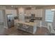 Beautiful kitchen with stainless steel appliances, center island with bar stools, and a view of the dining area at 2310 Raven Ridge Rd, Minneola, FL 34715