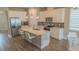 Modern kitchen boasts white cabinets, stainless steel appliances, and a large center island with seating at 2310 Raven Ridge Rd, Minneola, FL 34715