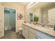 Bathroom featuring dual sinks with granite counters and access to the walk-in closet at 248 Cheshire Ct, Kissimmee, FL 34758