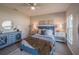 Comfortable bedroom with calming color palette, large bed, tile floors, dresser, and natural light at 248 Cheshire Ct, Kissimmee, FL 34758