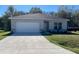 Charming single story home featuring well manicured lawn, two car garage and traditional landscaping at 248 Cheshire Ct, Kissimmee, FL 34758